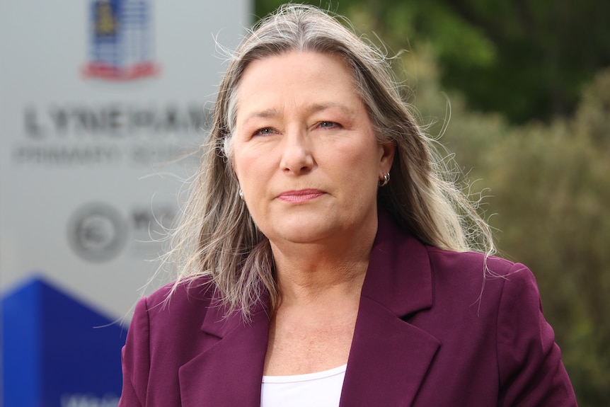 A woman with a maroon jacket on.