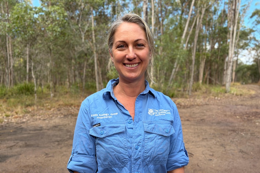 A woman in a blue shirt smiling into the camera
