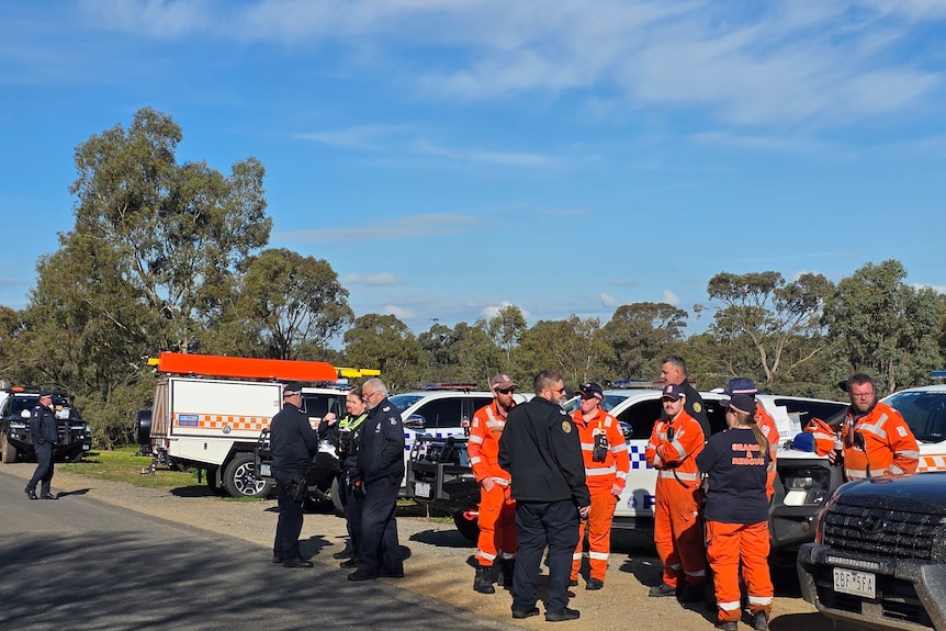 Police and SES crews near a bushy area.