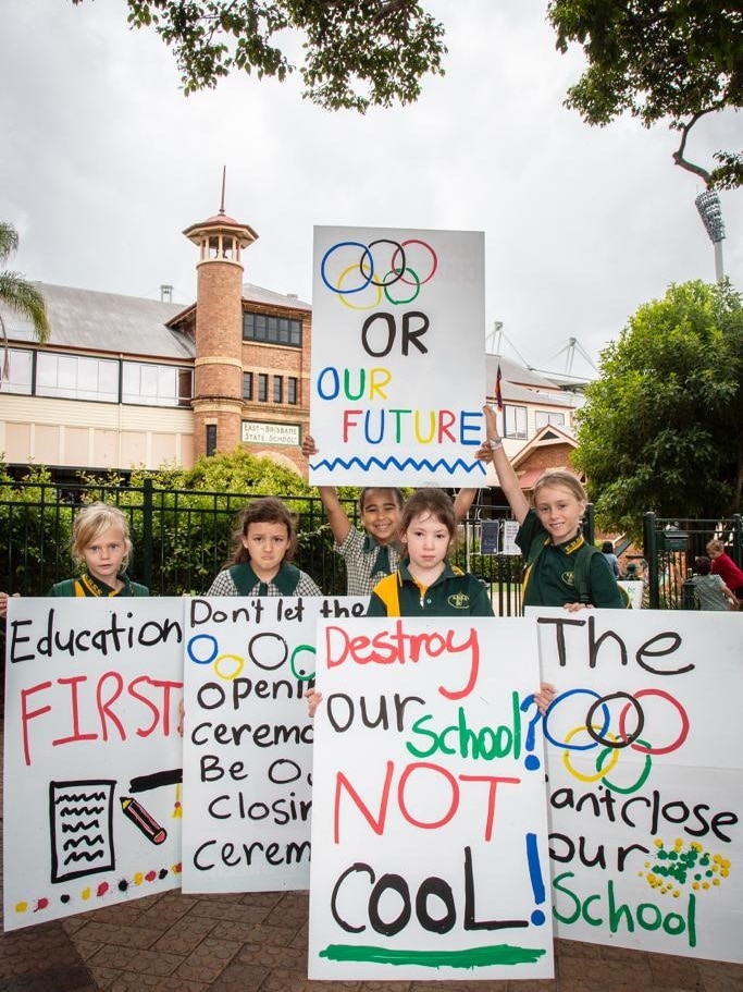 an image of students frowning holding up placards in front of their school