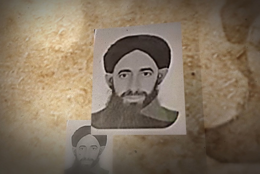 A man with a beard, wearing a dark head covering.