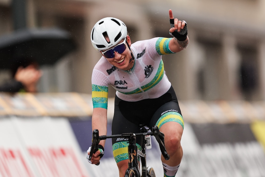 Tara Neyland holds up her hand on her bike