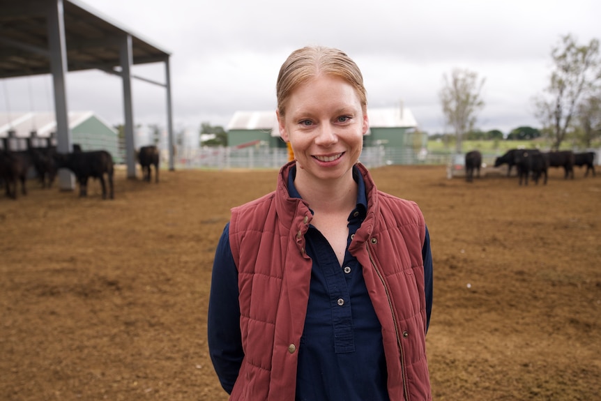 A farmer scientist smiling in a cattle yard.