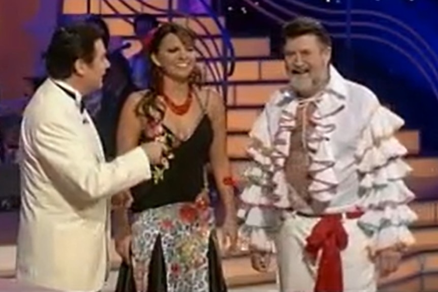 Daryl Somers in a white tuxedo with dancer Patrice Smith in a ballgown and Derryn Hinch wearing a tango frilly shirt
