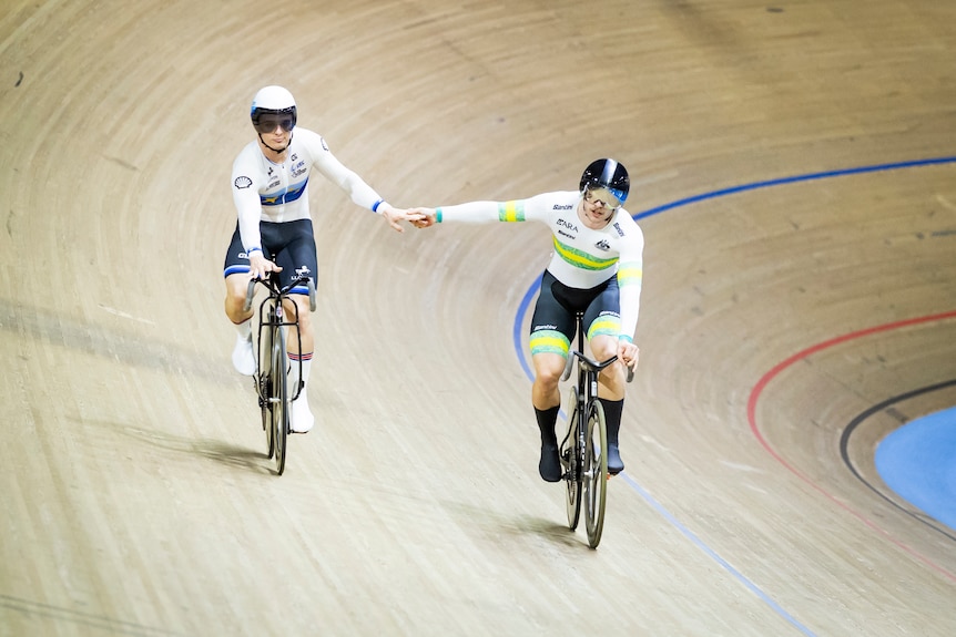Matthew Richardson and Leigh Hoffman hold hands on the track.