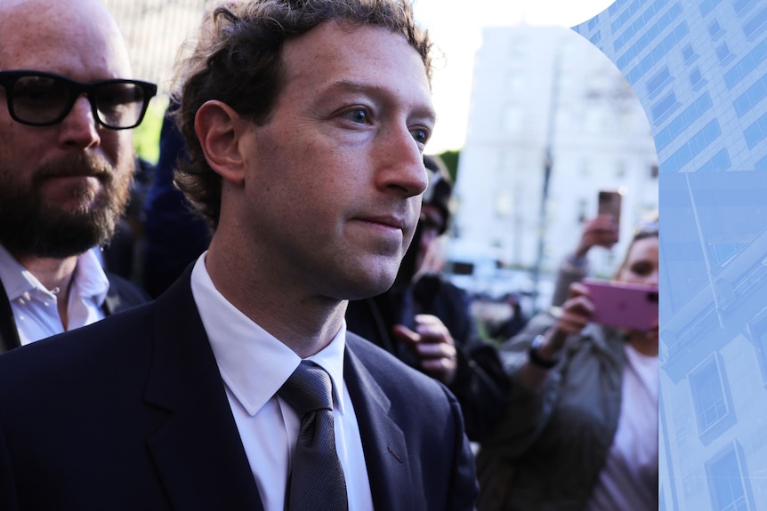 Mark Zuckerberg wearing a suit with several people pointing their phones and a camera at him.