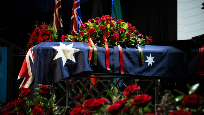 Derryn Hinch’s casket was draped in an Australian flag and surrounded by red roses.