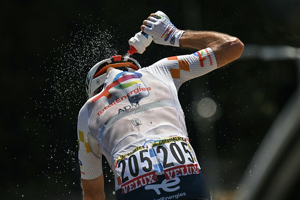 TotalEnergies team's French rider Thibault Guernalec douses himself with water to cool down as he cycles during the 3rd stage of the 113th edition of the Tour de France cycling race, 195,9 km between Granollers in Spain and Les Angles in southern France, on July 6, 2026. (Photo by Loic VENANCE / AFP)