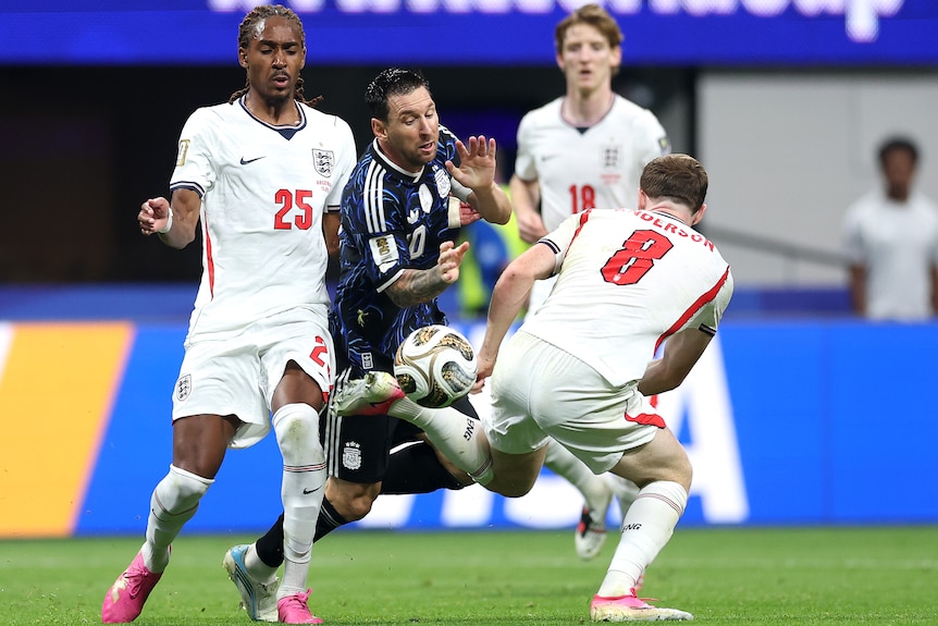 Lionel Messi tumbles under a tackle from Elliot Anderson