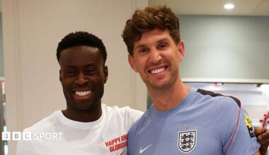 A picture of Guehi and Stones smiling at the camera at England's training camp in Kansas City