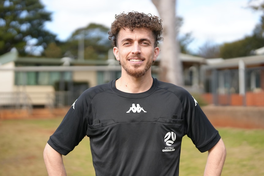 A smiling man in a black shirt.