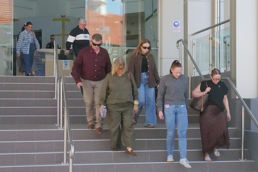 Group of seven people dressed nicely walking down courthouse steps