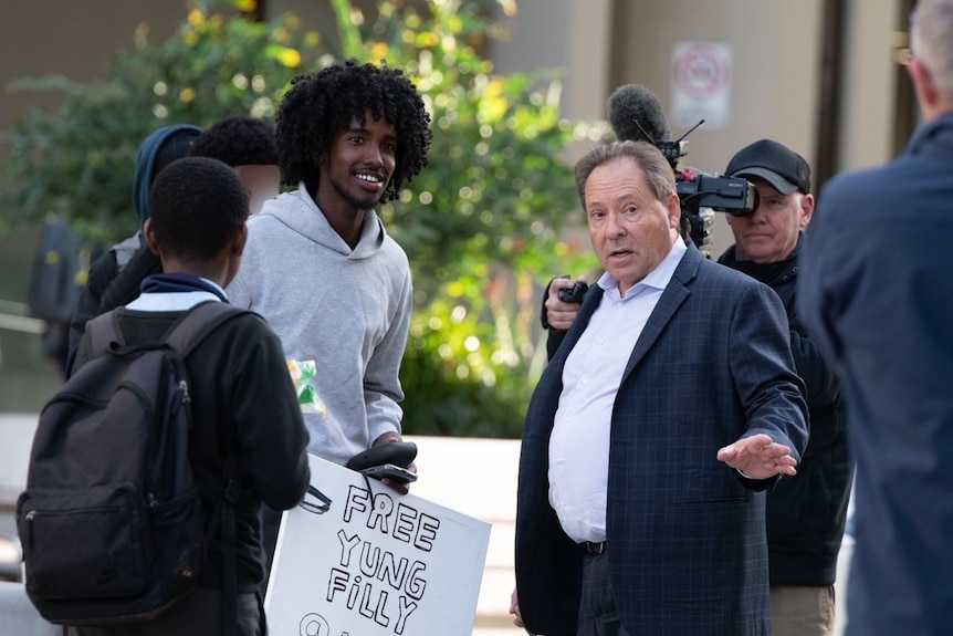 Yung Filly's defence lawyer, David Edwardson KC talking with Yung Filly fans outside court.
