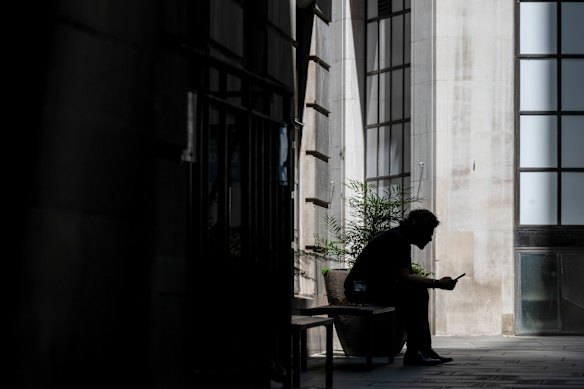 A man sits in the shade during a heatwave in the City of London on June 24, the same day the London School of Economics cancelled its event on extreme heat.