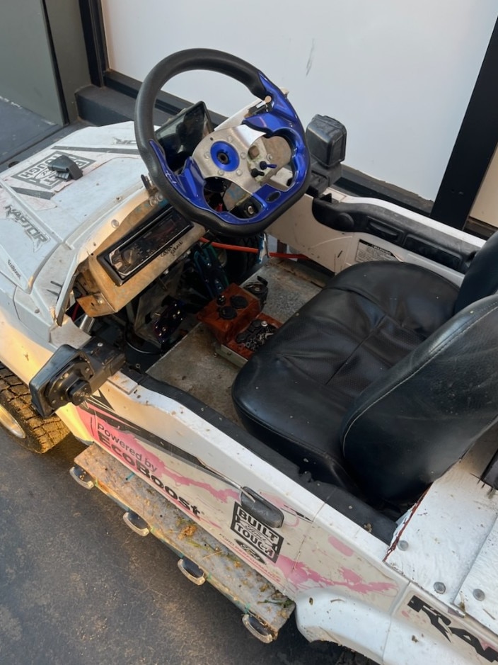 A homemade car at a police station showing a very small child's car with modifications