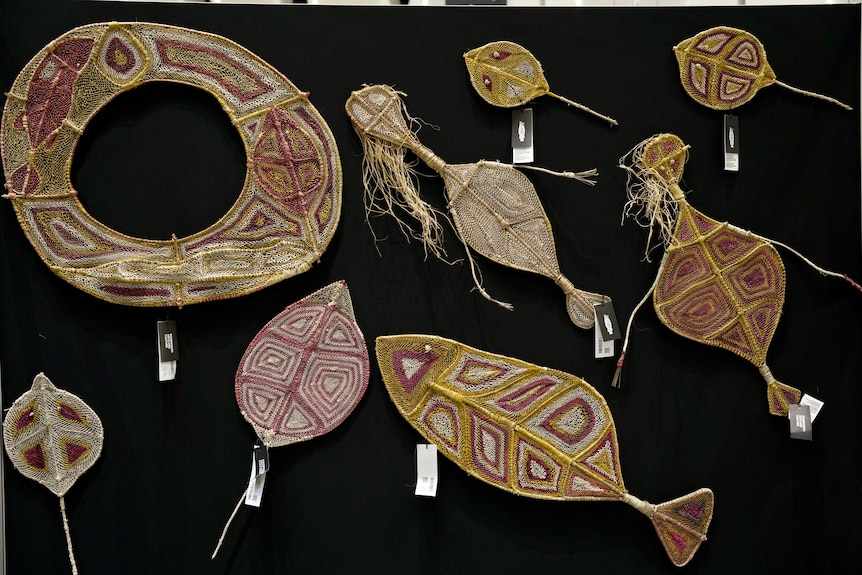 A collection of woven artworks, some shaped as sea animals.