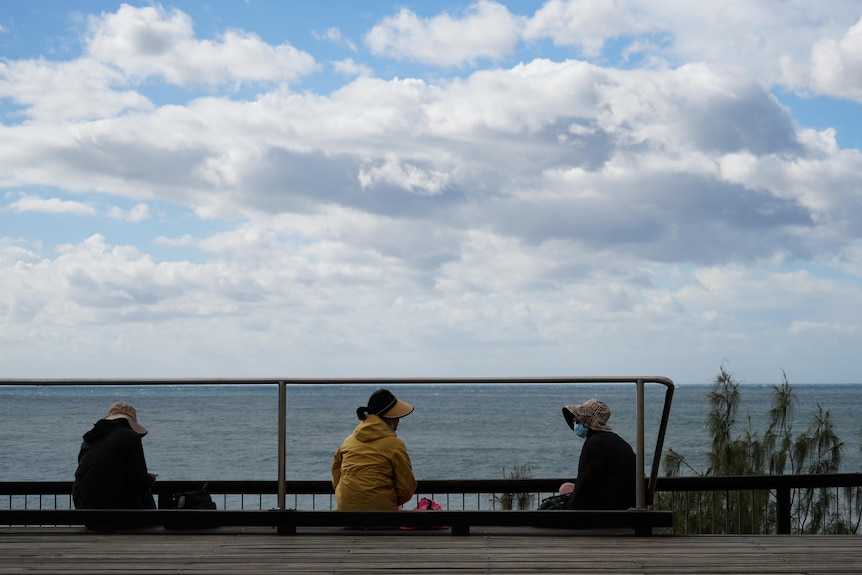 Women at beach wearing jumpers