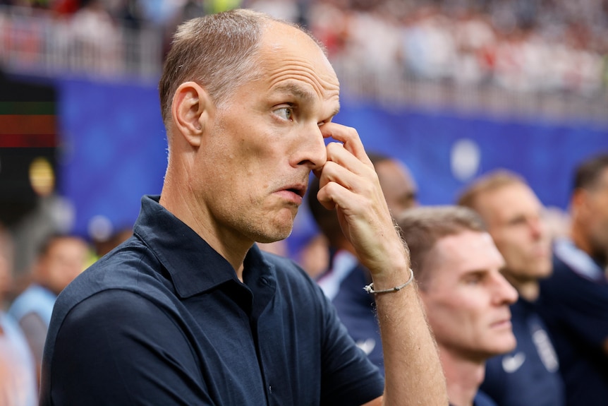 Thomas Tuchel scratches his face on the touchline