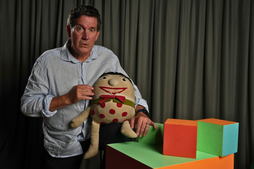 Rhys Muldoon pulls a silly face as he stands next to a Humpty Play School toy