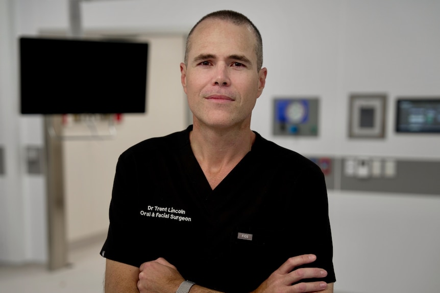 A man in a black top in a medical room