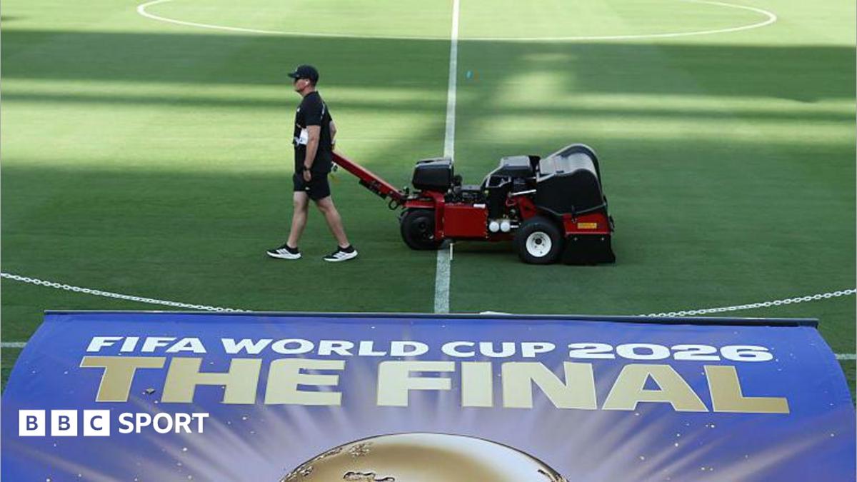 Staff attending to the field at the New York New Jersey Stadium with a sign for the 2026 World Cup final in the foreground