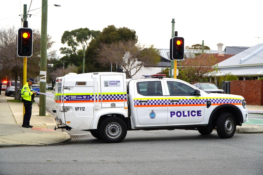 A police vehicle parks at traffic light intersection