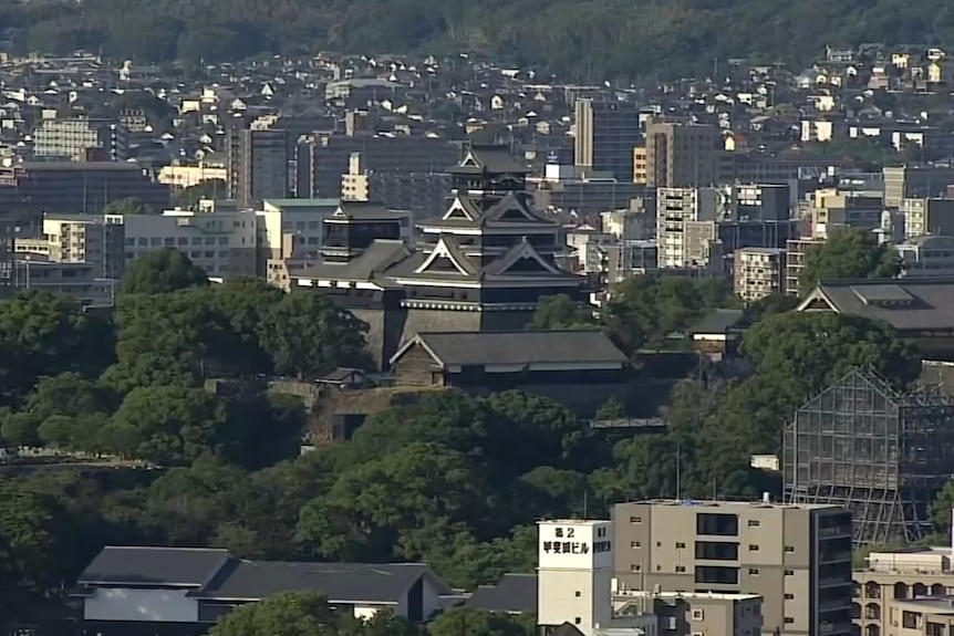 An aerial horizon shot showing the tops of Japanese high-rise buildings and at least one traditional tower.