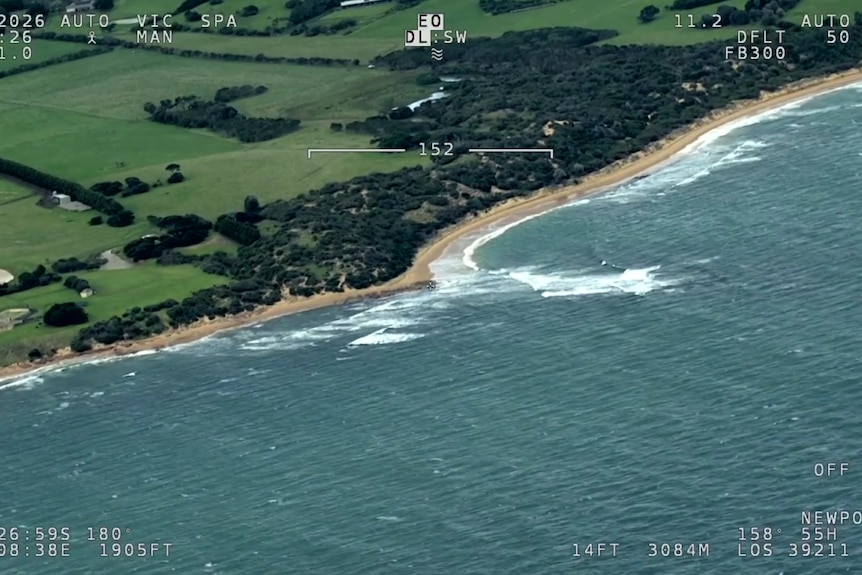 A birds-eye view of a segment of the Victorian coastline, featuring lush green fields. 