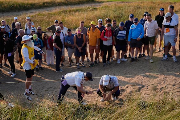 Lucas Herbert and a rules official look at the lie of his ball on the 17th hole. 