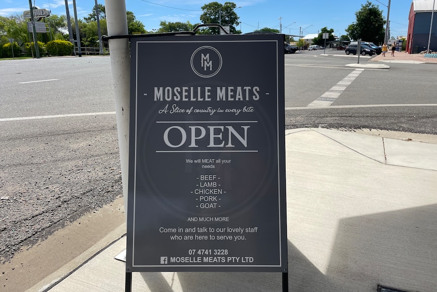Butcher shop sign on corner of road.