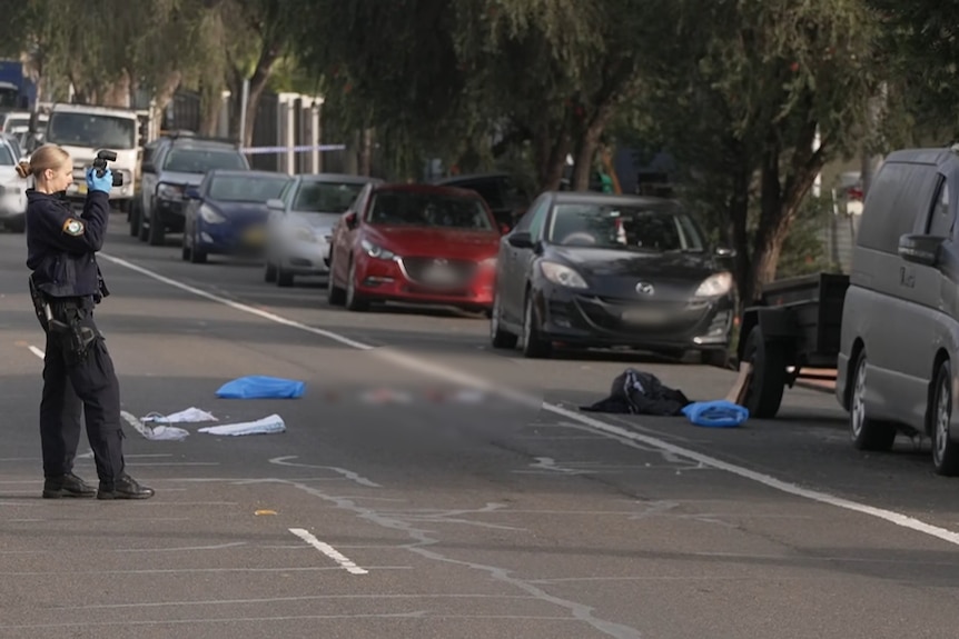 a forensic police officer takes pictures at a crime scene