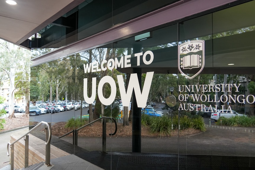 University of Wollongong sign on glass wall.