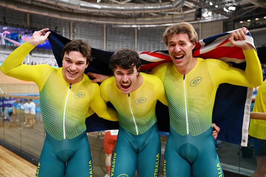 Three athletes in Australian kit celebrate a win at the Games