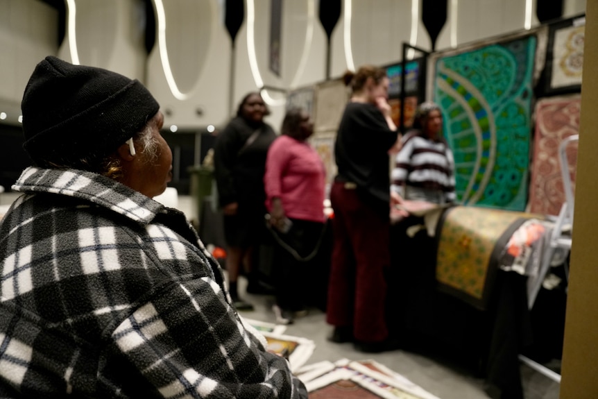 A person admiring the artwork at the National Indigenous Art Fair.
