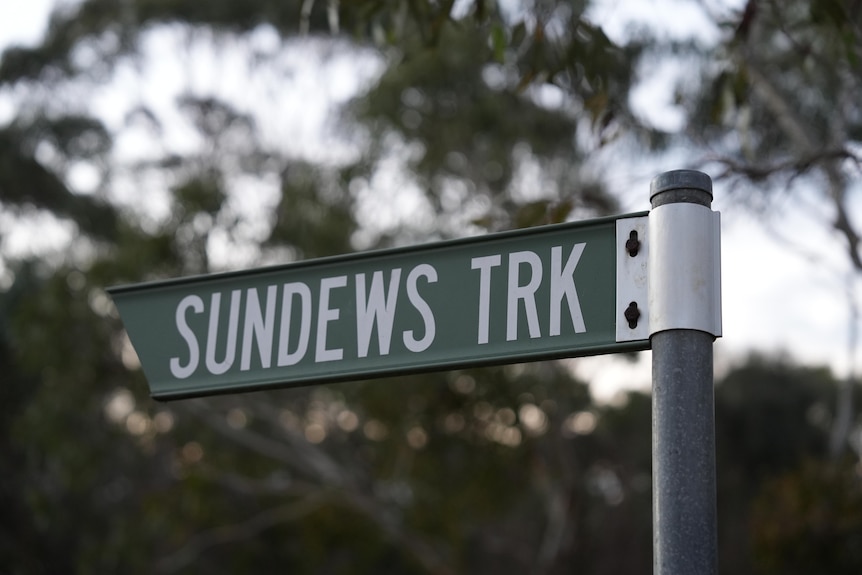 A green sign on a post which says Sunderws Trk