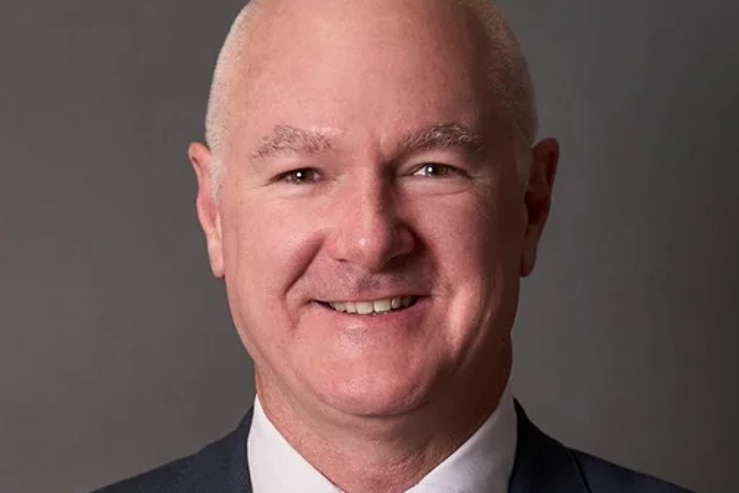 a man in a suit smailes at the camera