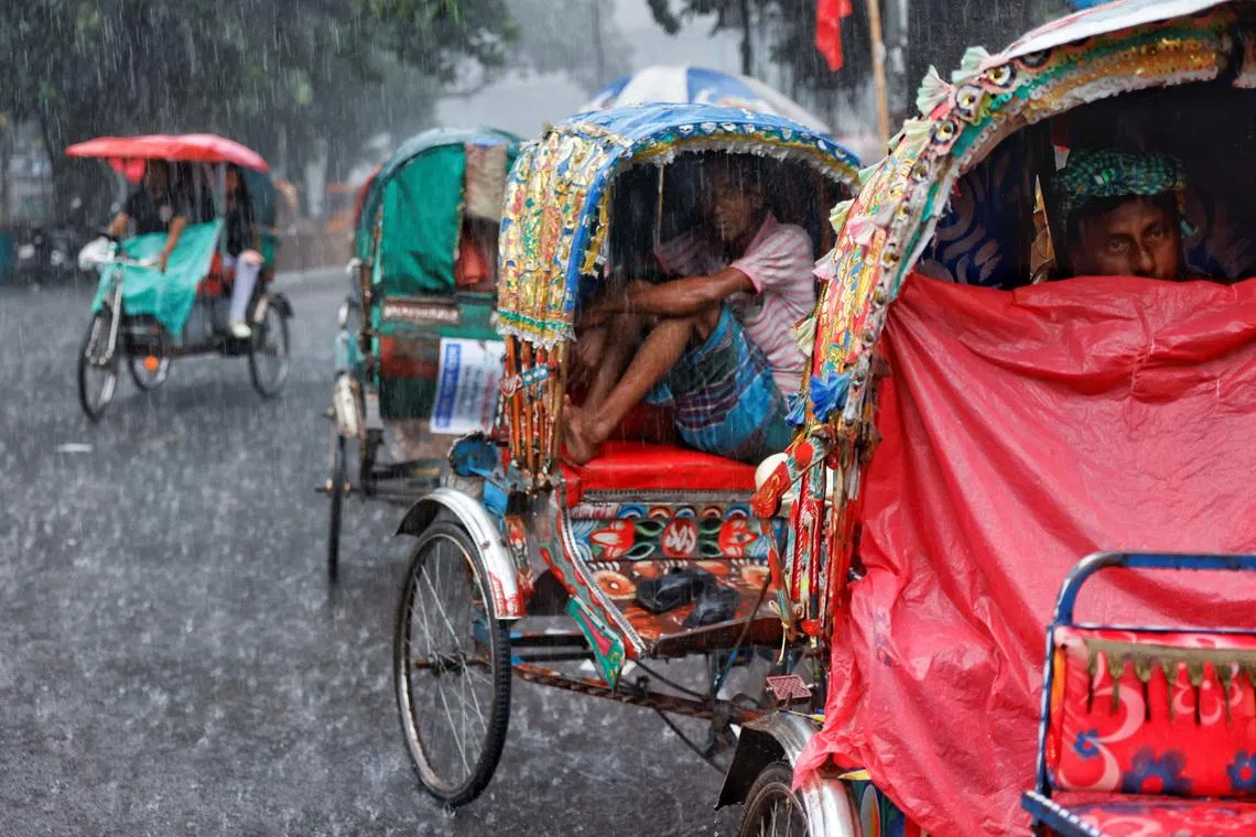 Rickshaw drivers sitting inside their rickshaws to take cover during torrential rain in Dhaka, Bangladesh, on July 7.