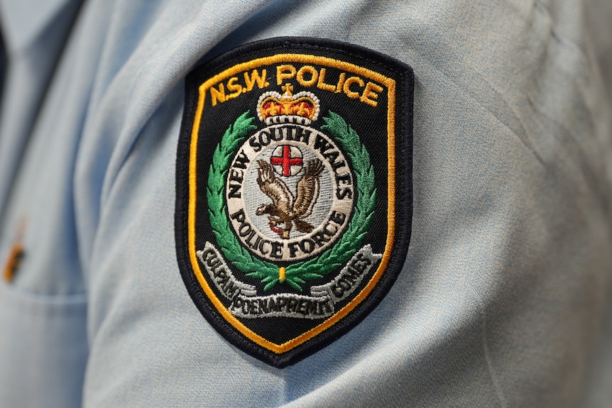 The NSW Police insignia on the shoulder of an officer's shirt.