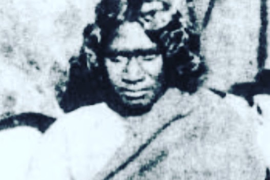 A black and white photo of woman looking at the camera.