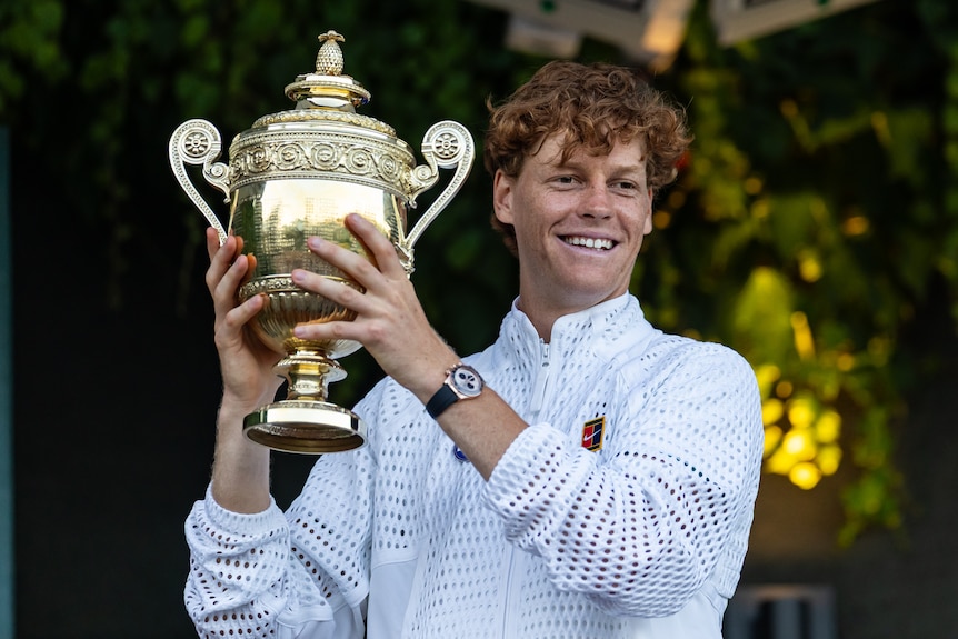 Jannik Sinner lifts the Wimbledon winner's trophy
