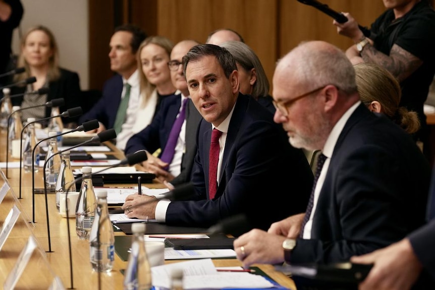Jim Chalmers leans forward to a microphone