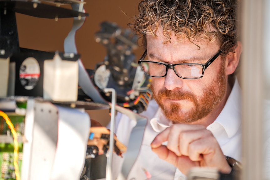 A man working on a robotic device.