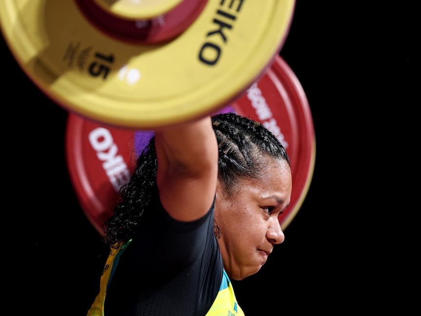 A woman competes during the weightlifting.