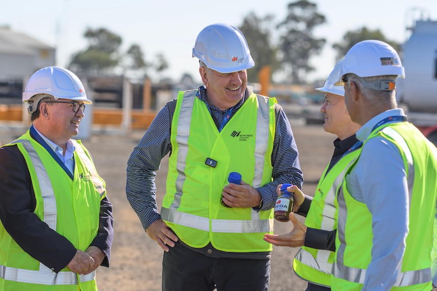 four men in hi vis speaking