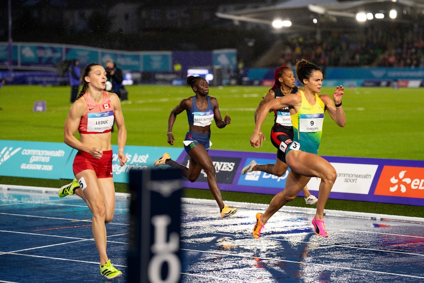 Torrie Lewis runs in her 100m semifinal with other athletes
