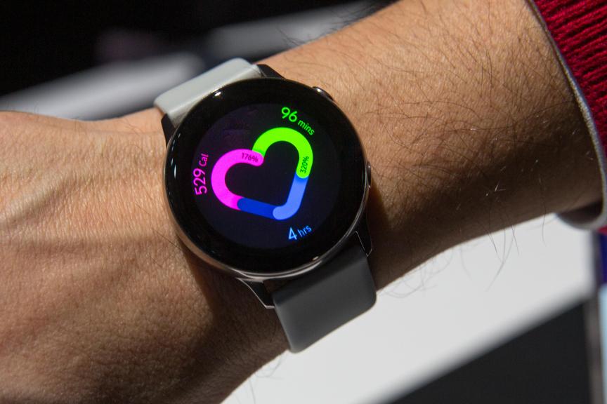 A round watch with a screen showing a heart-shaped graph. The graphic displays different health metrics.
