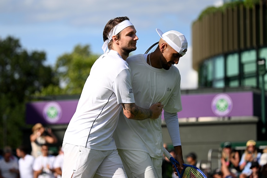 Alexander Bublik hugs Nick Kyrgios during their Wimbledon doubles match.