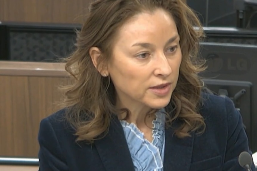 An image of a dark blonde woman wearing a blazer.