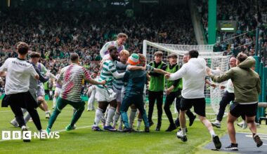 Celtic fans run on the pitch to celebrate a goal against Hearts, sparking a larger pitch invasion.