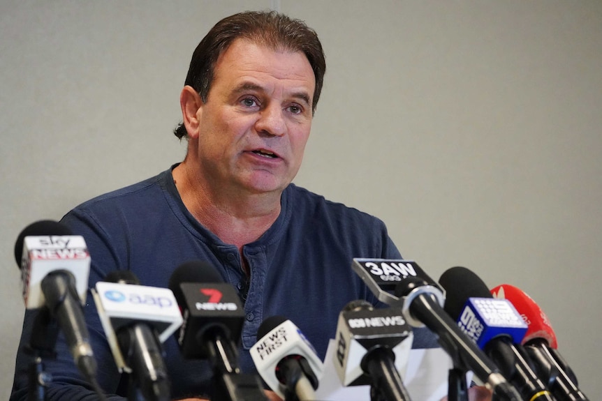 John Setka sitting behind a number of microphones at a Melbourne media conference.